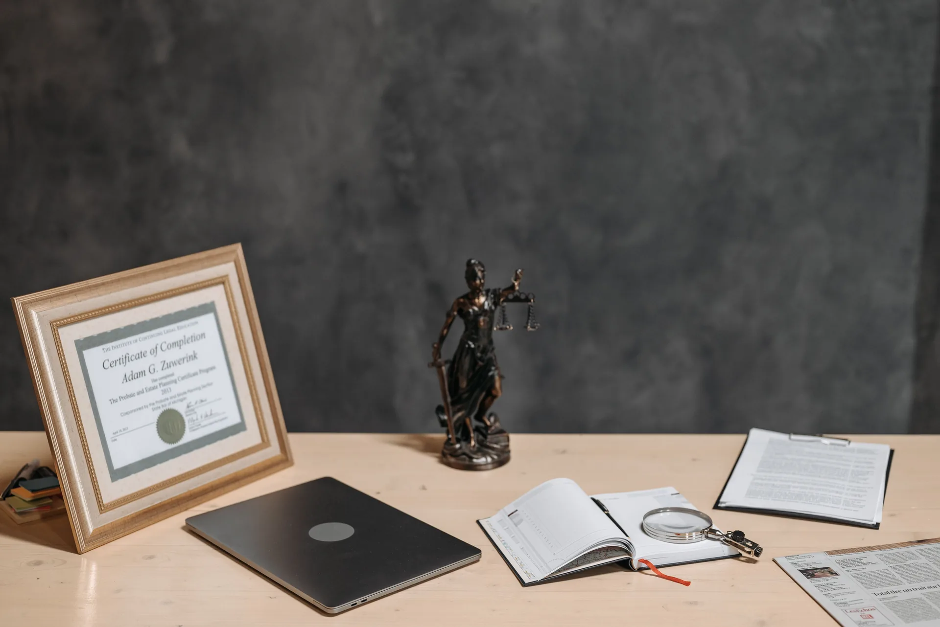 Formal desk with a framed document, open journal and magnifying glass