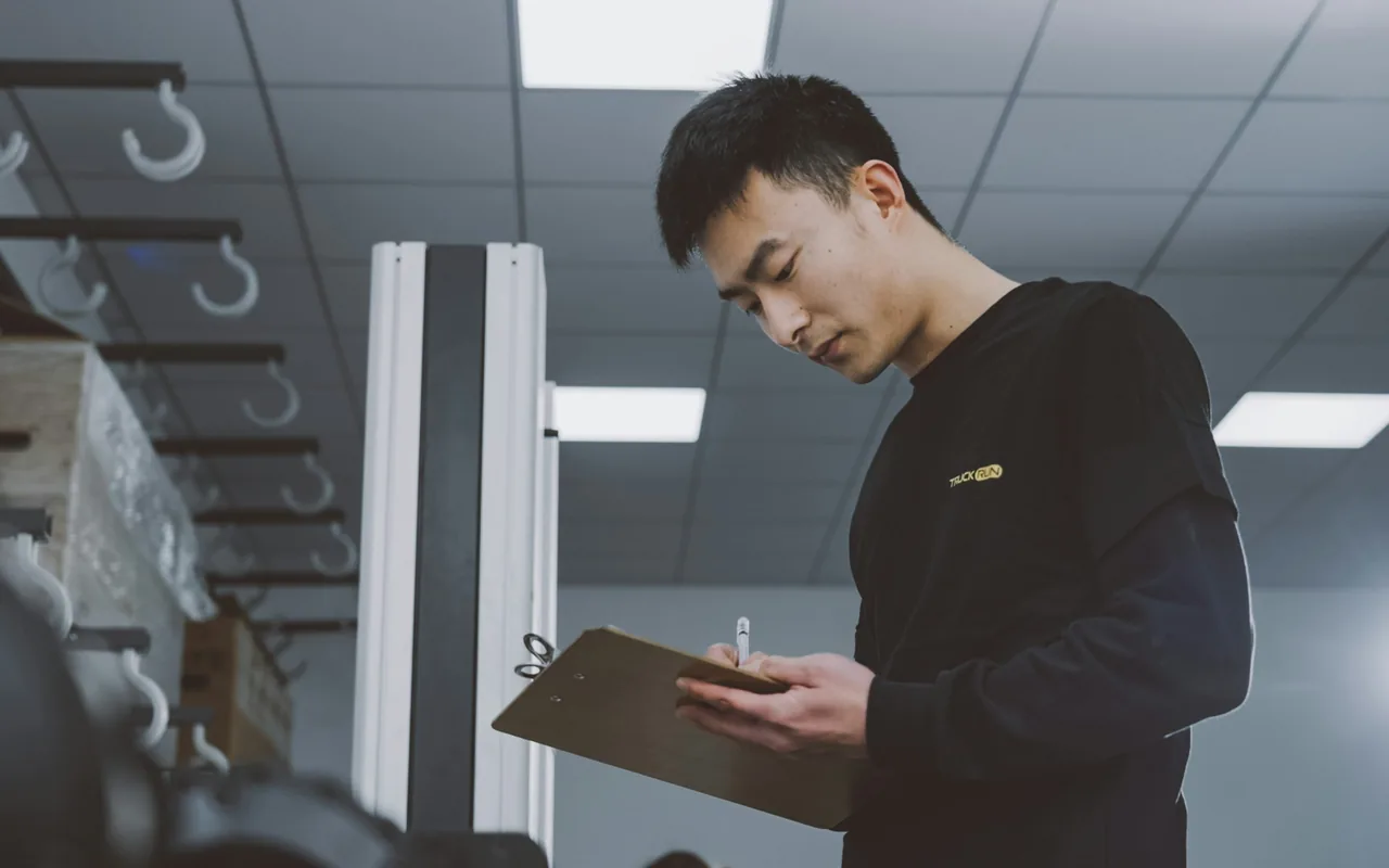 Quality reviewer checking facility information on a clipboard