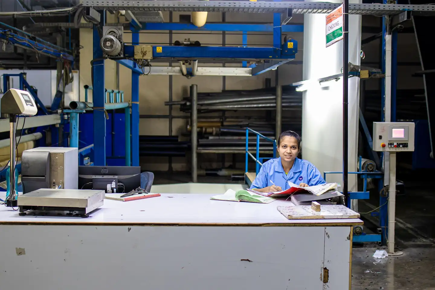 Production worker reviewing records at a factory desk