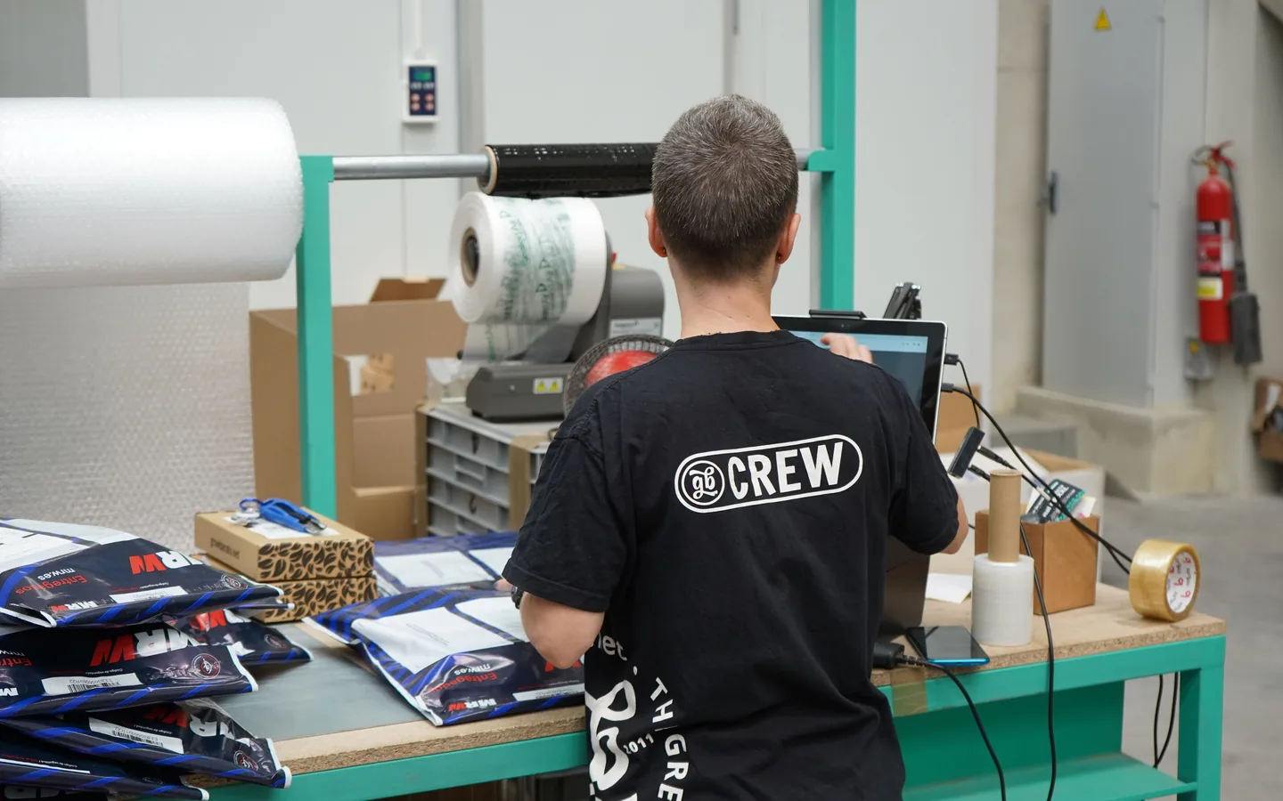 Trabajador revisando productos envasados en una estación de producción