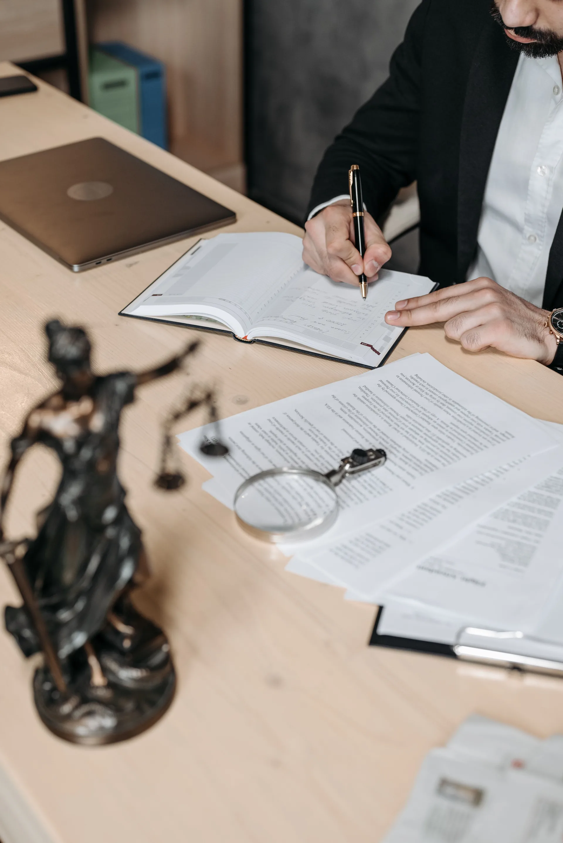 Professional reviewing documents at a desk with a magnifying glass